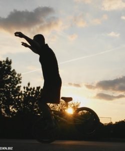 BMX Flatland riding at sunrise: no hand hang ten trick